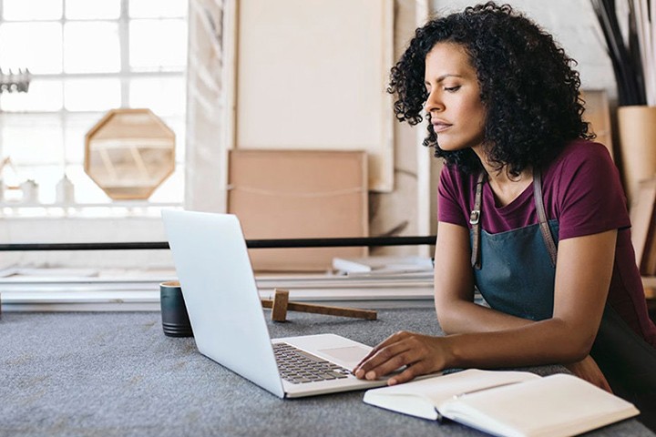 Women in apron using laptop