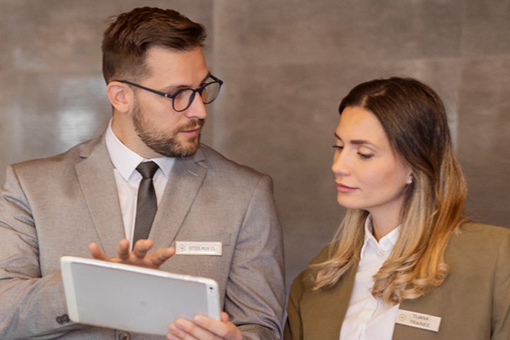 Hospitality professionals reviewing data on an iPad tablet