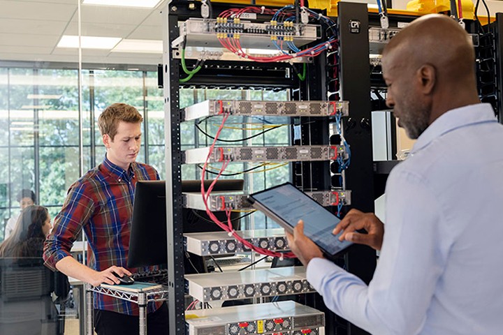 Server engineers reviewing data in server room at a business