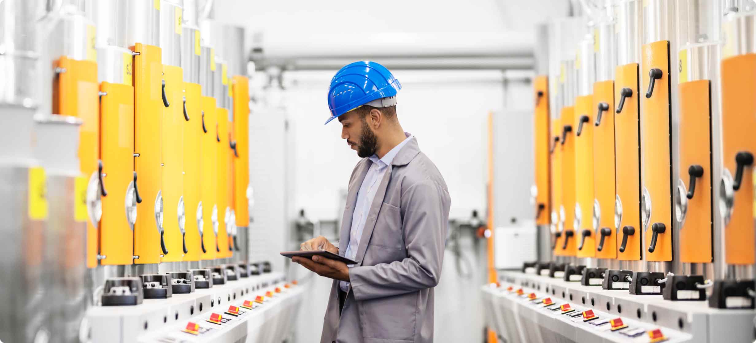 helmeted man checking tablet readouts