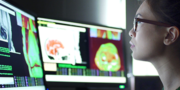 A healthcare professional viewing scans on the monitor.