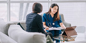 Female healthcare professional explaining medical report to female patient