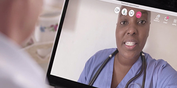 A doctor speaking to a patient virtually on a laptop.