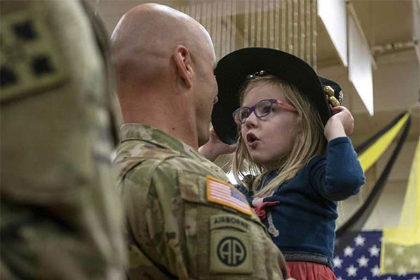 Airborne soldier holding and having a moment with his daughter.