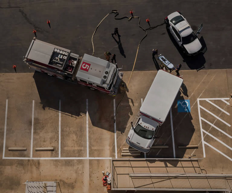 Aerial view of first responder vehicles in parking lot with Police, Fire, EMS
