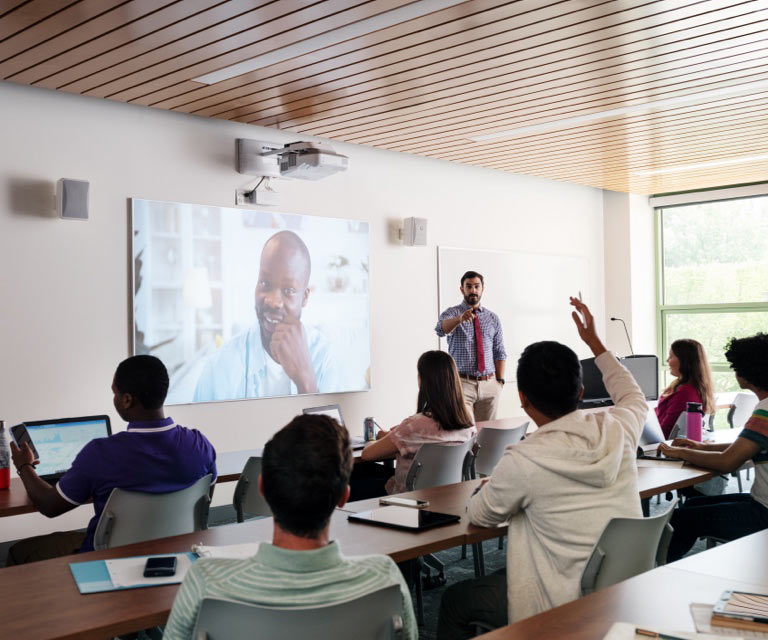 students in classroom watching video screen