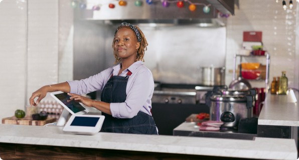 Woman using POS system in restaurant