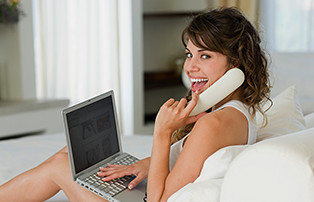 Woman using Fios Digital Voice while also on laptop.
