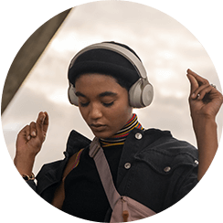 Foto de una mujer joven usando audífonos para escuchar música